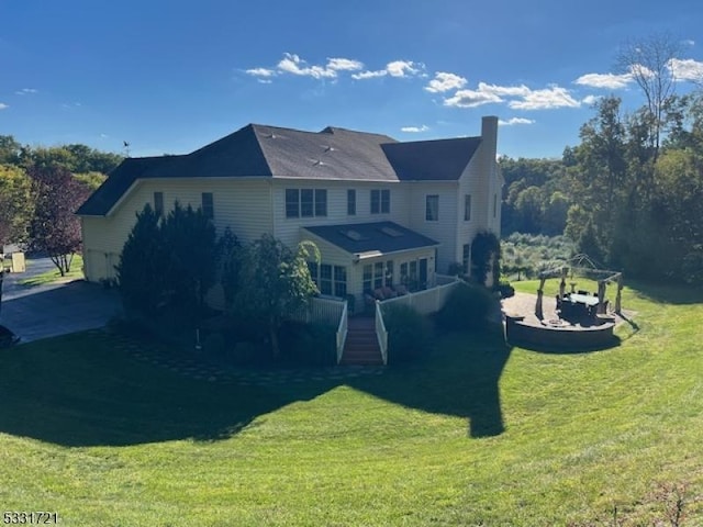 rear view of house featuring a yard