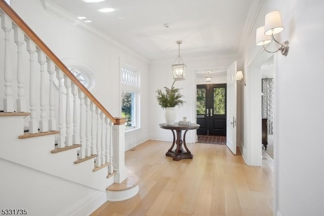 foyer with hardwood / wood-style floors and ornamental molding