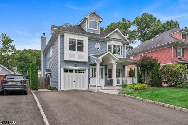 view of front facade featuring a garage, a porch, and a front lawn