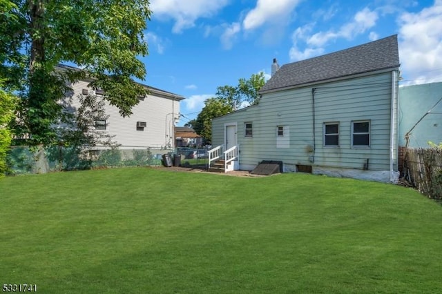 rear view of house featuring a yard