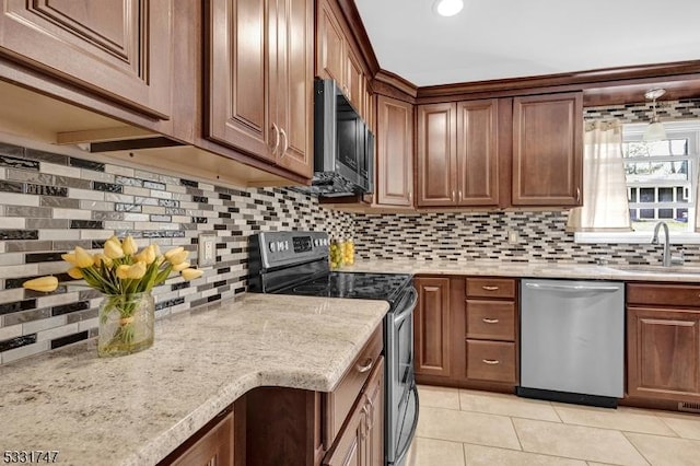 kitchen with light tile patterned floors, appliances with stainless steel finishes, a sink, and tasteful backsplash
