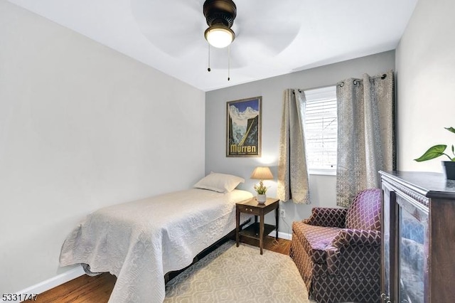 bedroom featuring baseboards, a ceiling fan, and wood finished floors