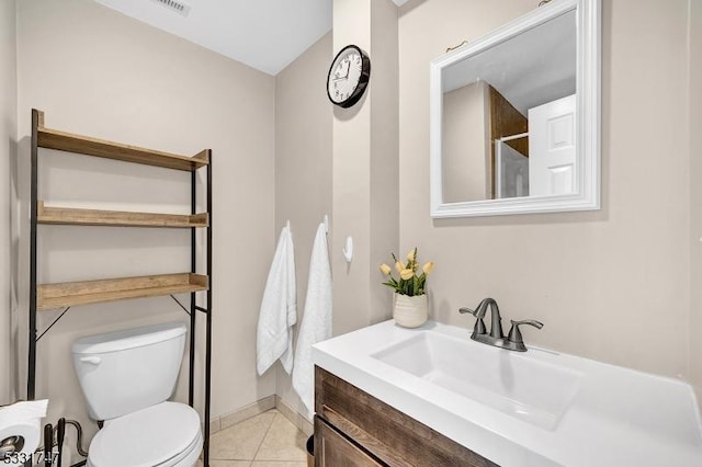 bathroom featuring vanity, baseboards, tile patterned floors, and toilet