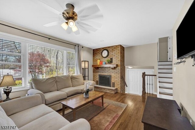 living room with a healthy amount of sunlight, ceiling fan, a fireplace, and wood finished floors