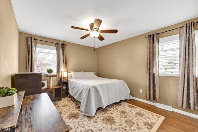 bedroom with a ceiling fan, baseboards, visible vents, and light wood-type flooring