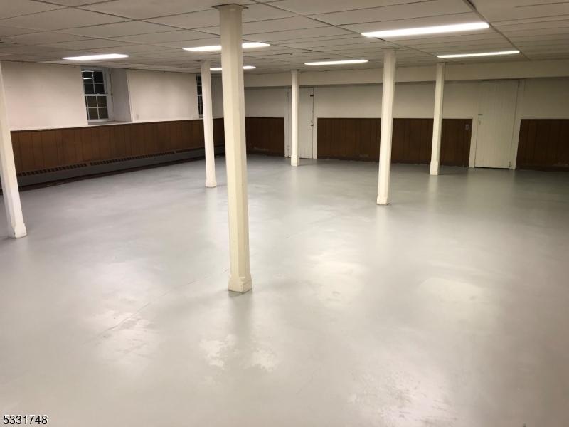 basement with a drop ceiling and baseboard heating