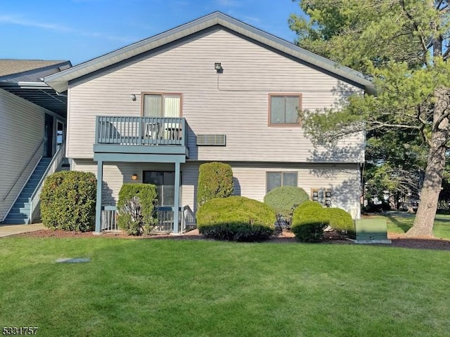 back of house with a yard and a balcony