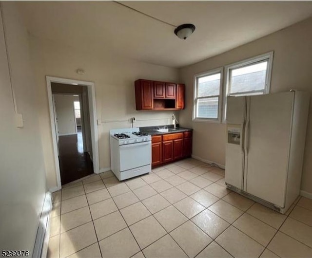 kitchen featuring light tile patterned floors and white appliances