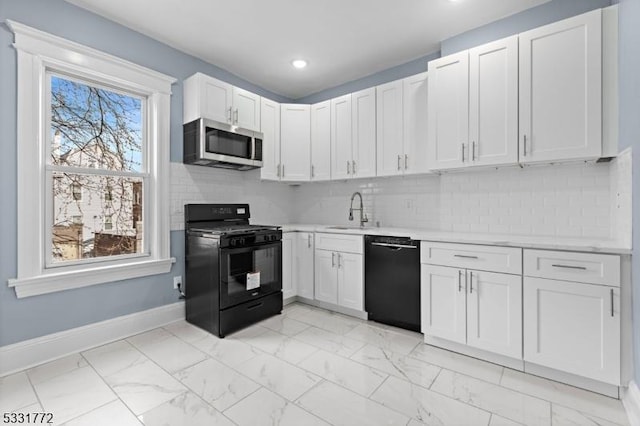 kitchen with white cabinets, sink, tasteful backsplash, and black appliances