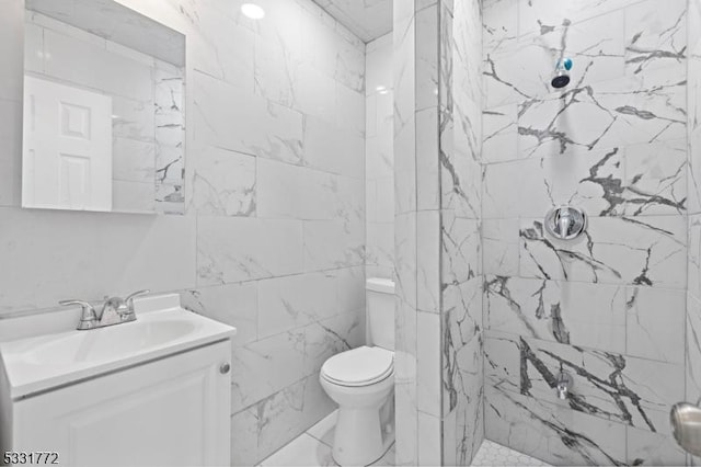 bathroom with vanity, a tile shower, and toilet