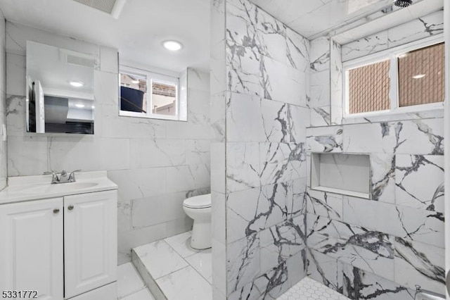 bathroom featuring vanity, tiled shower, and toilet