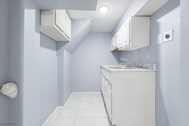 clothes washing area with sink and cabinets