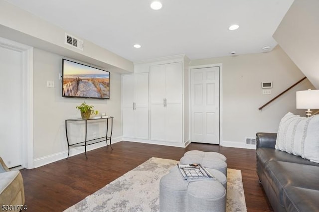 living room featuring baseboards, dark wood-style flooring, and visible vents