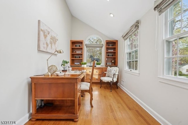 office space with baseboards, light wood-type flooring, and a wealth of natural light