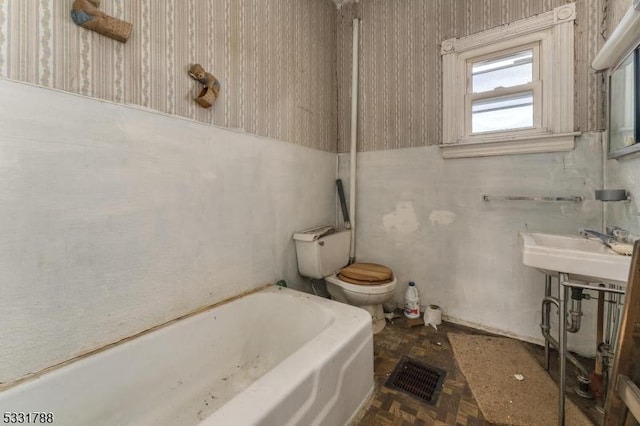 bathroom with toilet and a tub