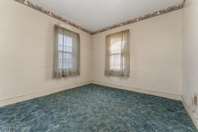 unfurnished room featuring dark carpet