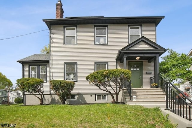 view of front of house with a front lawn and a chimney