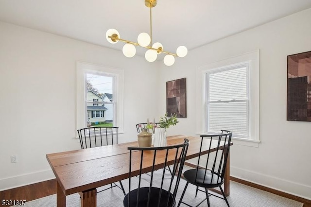 dining room with a chandelier, baseboards, and wood finished floors