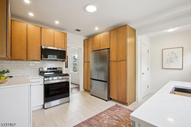 kitchen with a sink, stainless steel appliances, light stone counters, recessed lighting, and backsplash