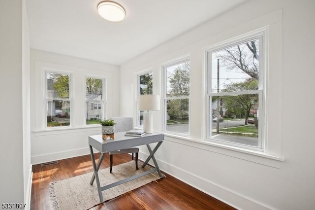 office area with dark wood-type flooring, baseboards, and a healthy amount of sunlight