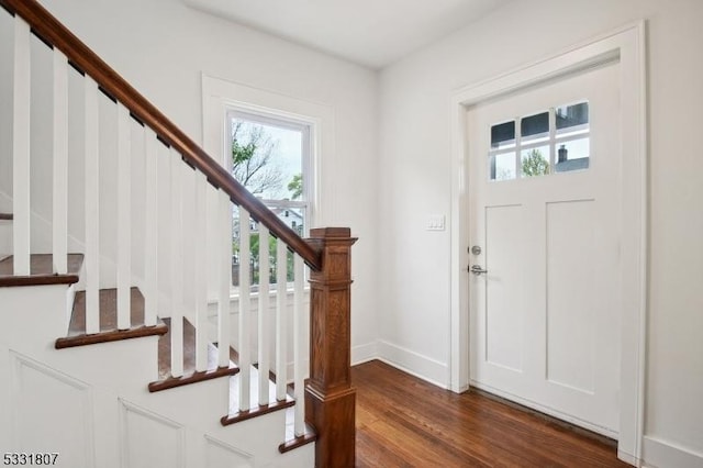entrance foyer featuring stairway, dark wood-style flooring, and baseboards