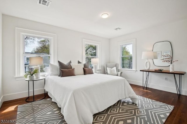 bedroom with multiple windows, visible vents, and baseboards