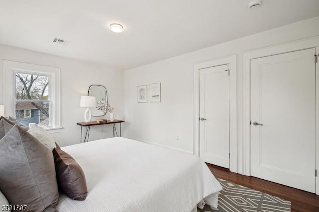 bedroom featuring visible vents and dark wood finished floors