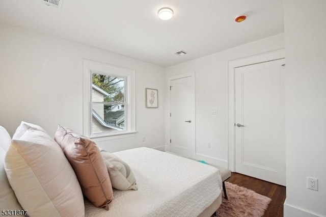 bedroom with visible vents and dark wood-style flooring