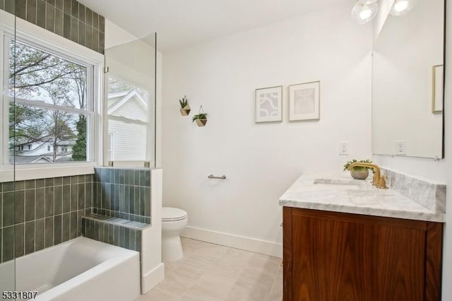 bathroom featuring a bath, plenty of natural light, baseboards, and vanity