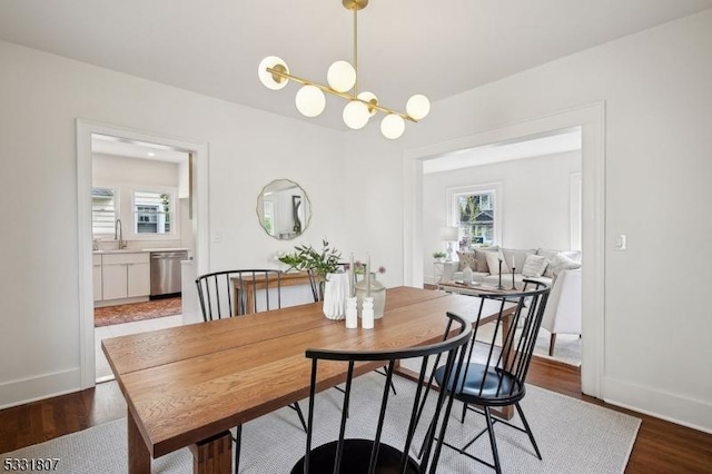 dining space with dark wood-style flooring, baseboards, and a notable chandelier