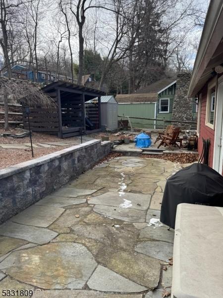 view of patio / terrace featuring area for grilling and a storage shed