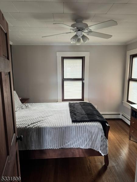 bedroom featuring hardwood / wood-style flooring, ceiling fan, and crown molding