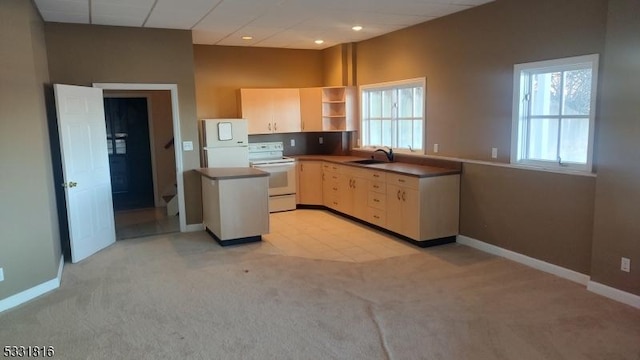 kitchen featuring light carpet, white appliances, plenty of natural light, and sink