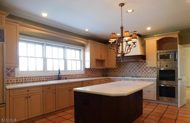 kitchen featuring pendant lighting, sink, decorative backsplash, appliances with stainless steel finishes, and a kitchen island