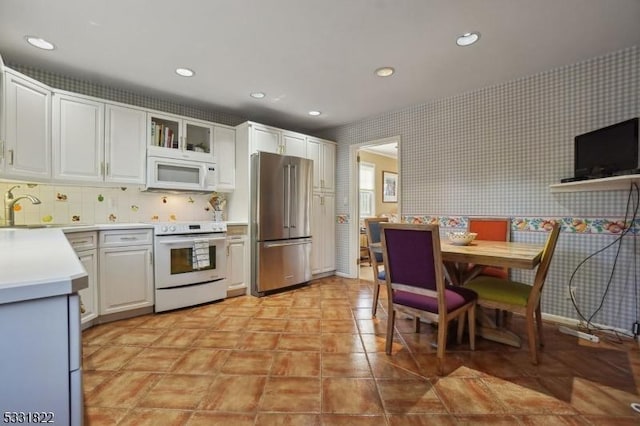 kitchen featuring white appliances, white cabinets, and sink