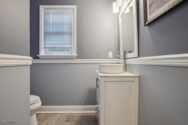 bathroom with toilet, vanity, and hardwood / wood-style flooring