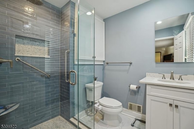 bathroom featuring toilet, an enclosed shower, and vanity