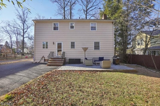 rear view of property featuring a patio area and a lawn