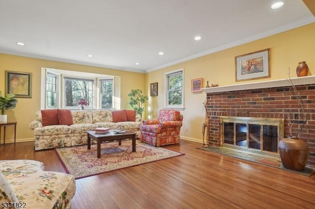 living room with a brick fireplace, crown molding, and wood-type flooring