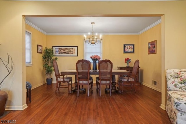 dining room featuring a chandelier, crown molding, and dark hardwood / wood-style flooring