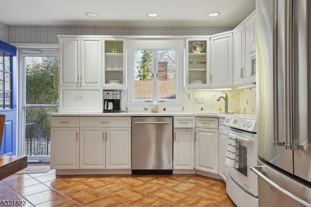 kitchen with tasteful backsplash, stainless steel appliances, white cabinetry, and plenty of natural light