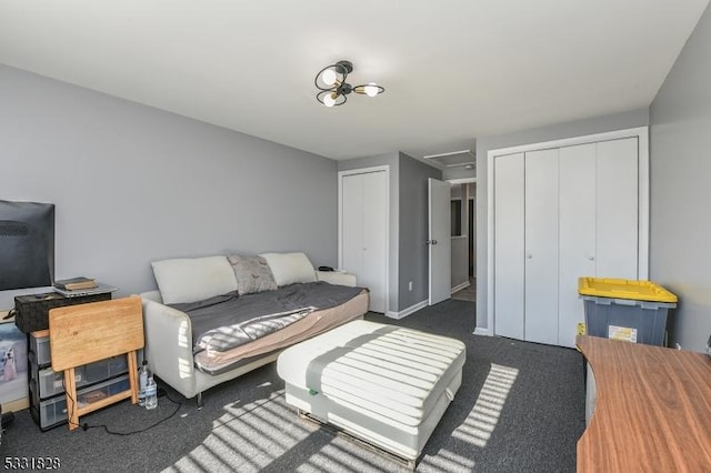 bedroom with dark carpet and multiple closets