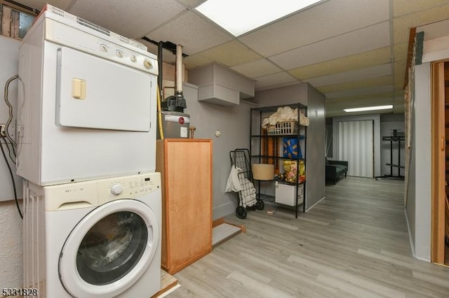 laundry area with light wood-type flooring and stacked washing maching and dryer