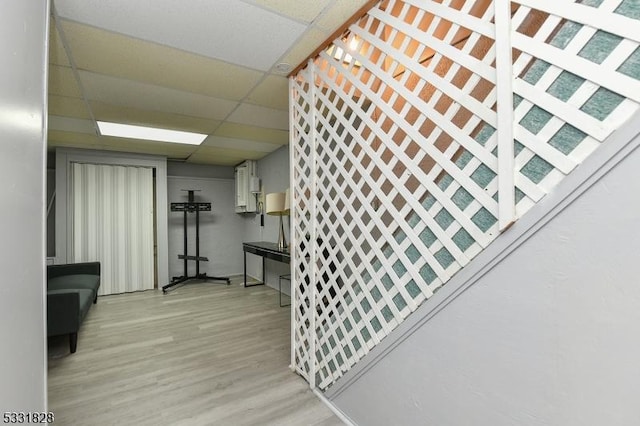 interior space with a paneled ceiling and light hardwood / wood-style flooring