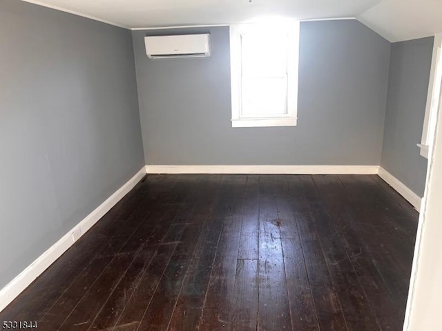 bonus room featuring vaulted ceiling, dark wood-type flooring, and a wall mounted AC