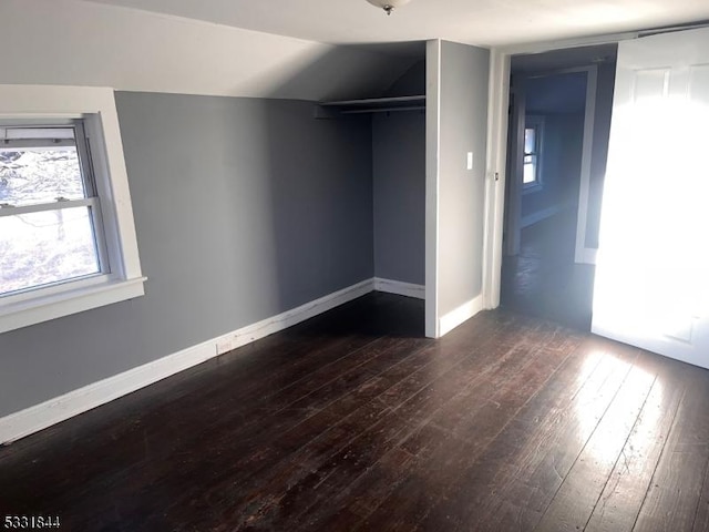 unfurnished bedroom featuring a closet and dark wood-type flooring