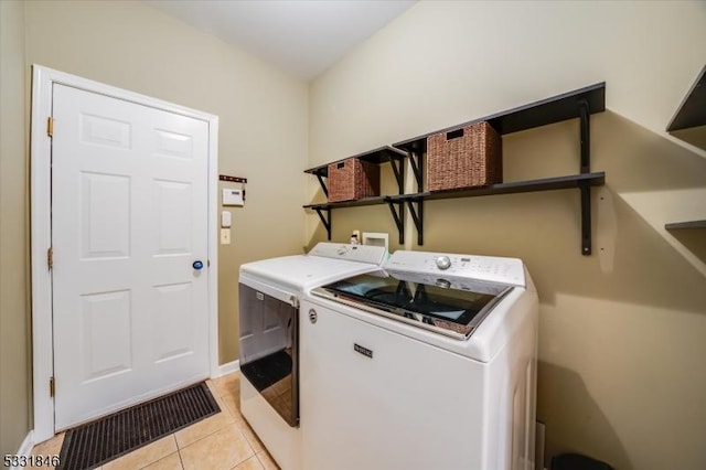 washroom with washer and dryer and light tile patterned floors