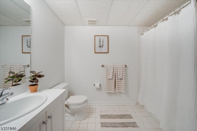 bathroom featuring toilet, a paneled ceiling, tile patterned flooring, and vanity