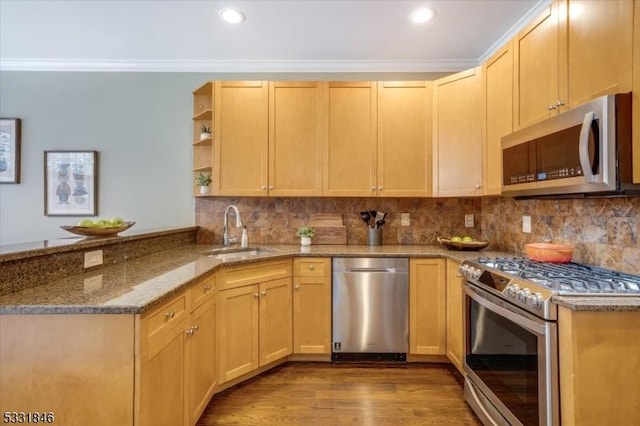 kitchen with kitchen peninsula, stainless steel appliances, light brown cabinets, and sink