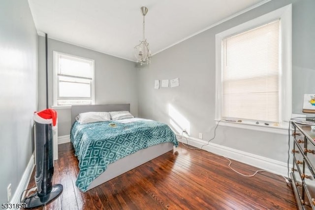 bedroom featuring a chandelier and dark wood-type flooring